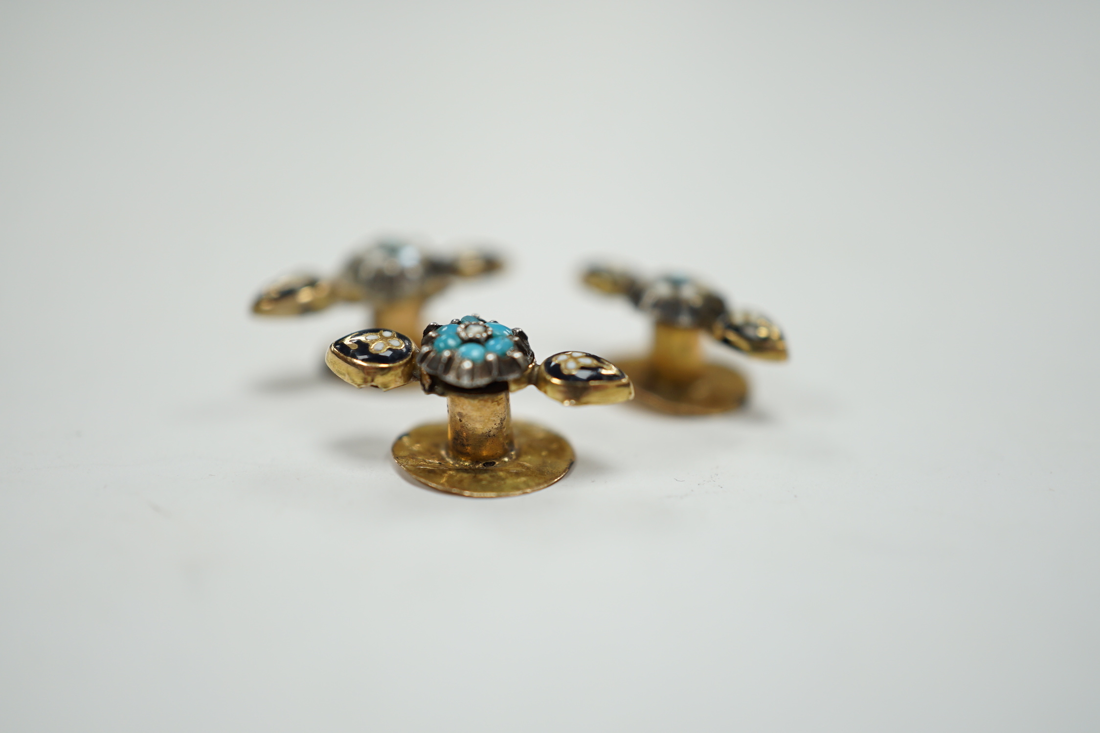 A small pair of antique yellow metal, two colour enamel, turquoise and seed pearl dress studs, 15mm and one other similar dress stud, gross weight 1.4 grams.